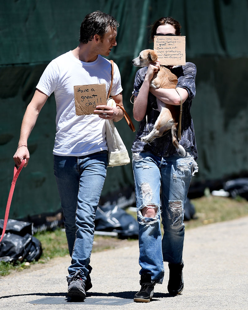 EXCLUSIVE: Anne Hathaway and Adam Shulman hold signs in front of their faces on a beautiful day in Brooklyn, NY