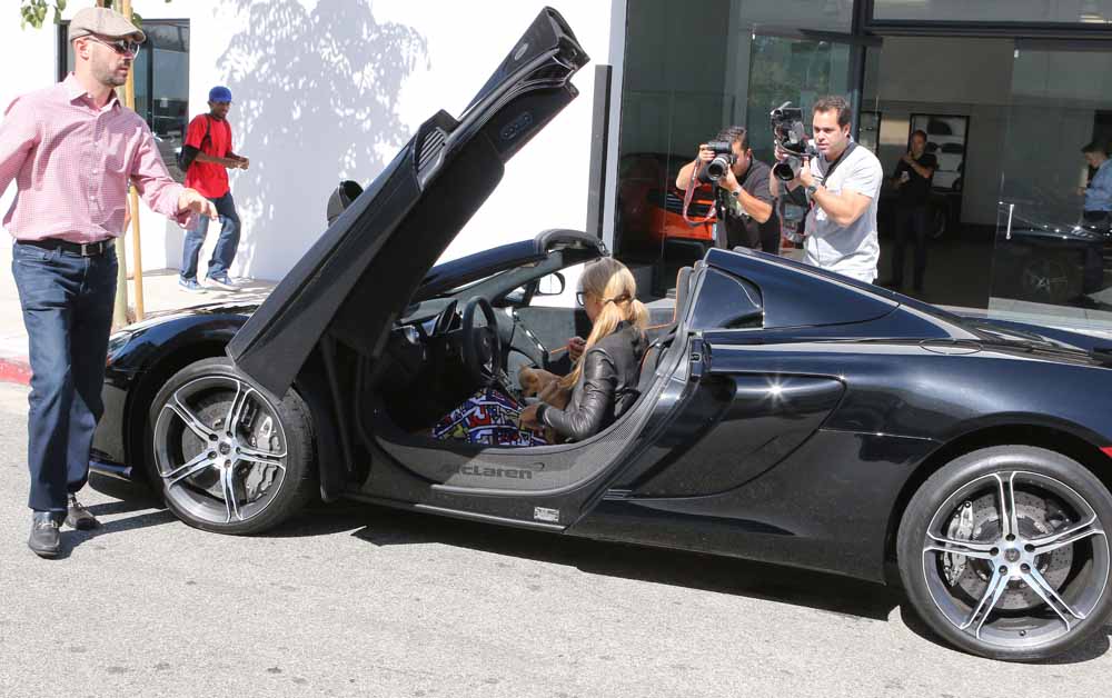 Paris Hilton takes her pet dog with her as she checks out a new McClaren Sports car at a dealership in Beverly Hills, C