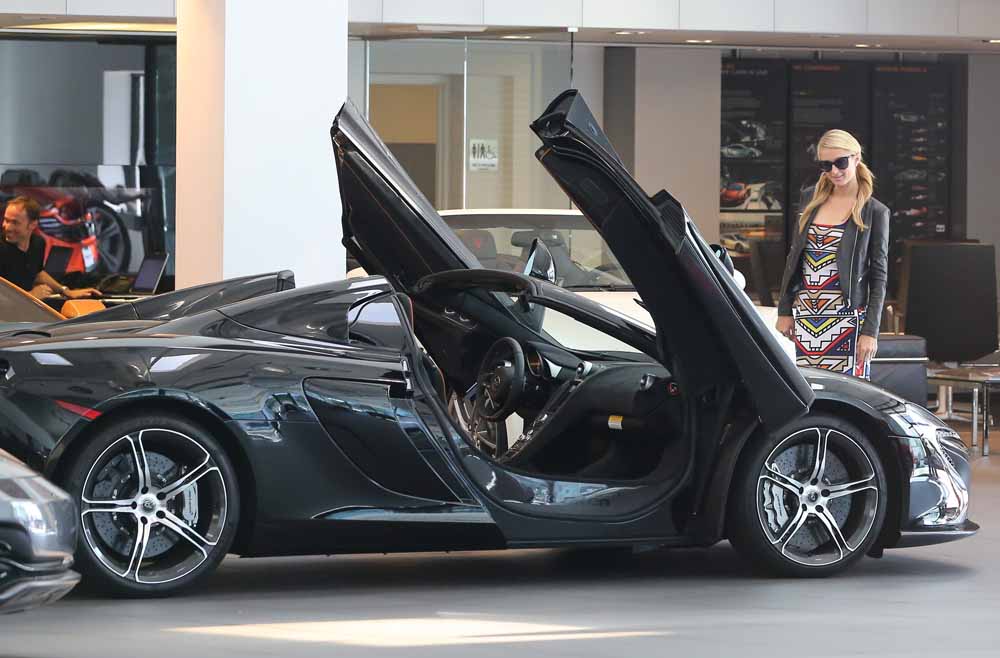 Paris Hilton takes her pet dog with her as she checks out a new McClaren Sports car at a dealership in Beverly Hills, C