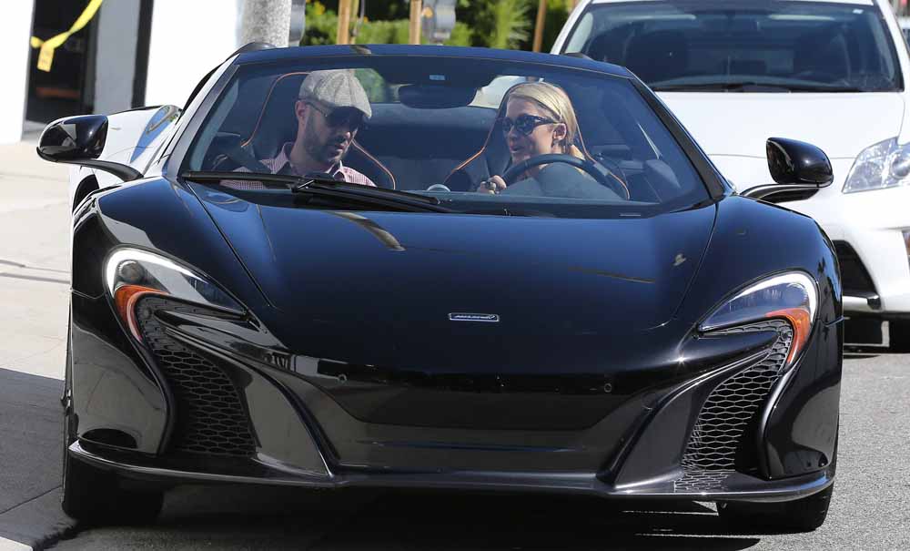 Paris Hilton takes her pet dog with her as she checks out a new McClaren Sports car at a dealership in Beverly Hills, C