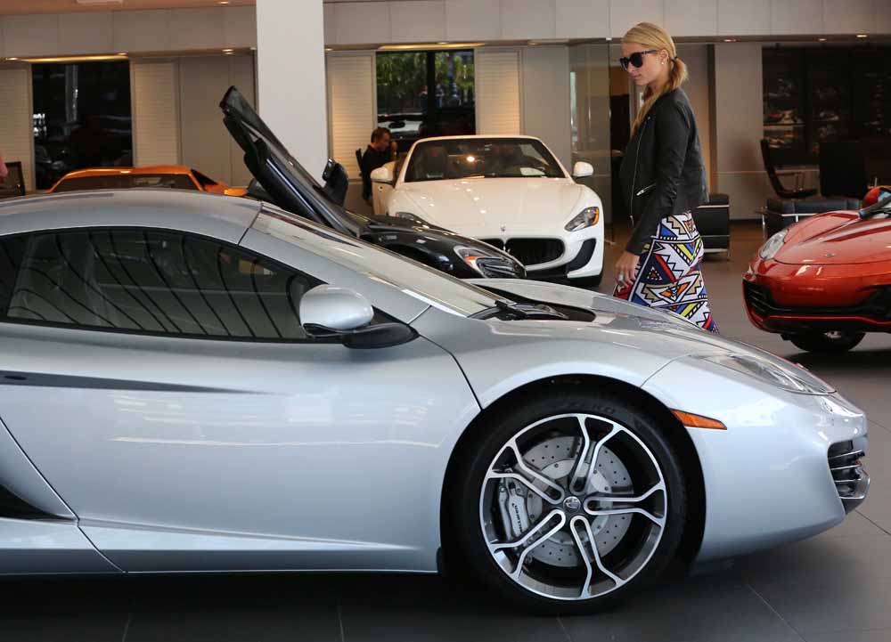 Paris Hilton takes her pet dog with her as she checks out a new McClaren Sports car at a dealership in Beverly Hills, C